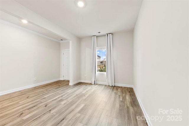 unfurnished room featuring baseboards and light wood-style flooring