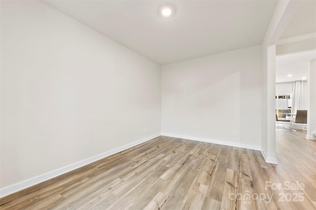 empty room with light wood-type flooring and baseboards