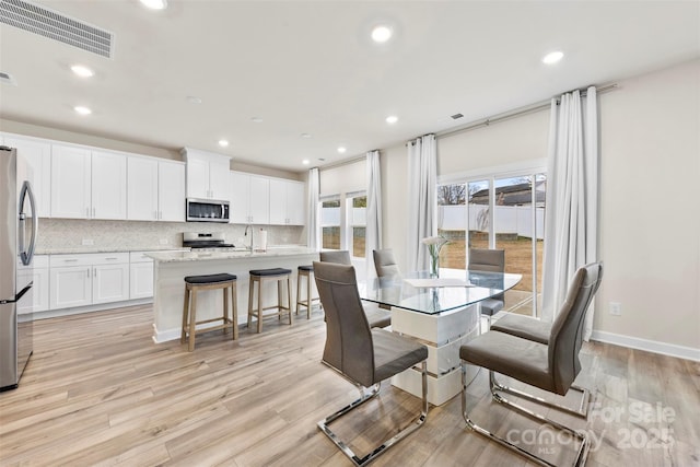 dining space featuring recessed lighting, visible vents, baseboards, and light wood-style floors