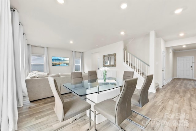 dining room with recessed lighting, light wood-style flooring, and stairs