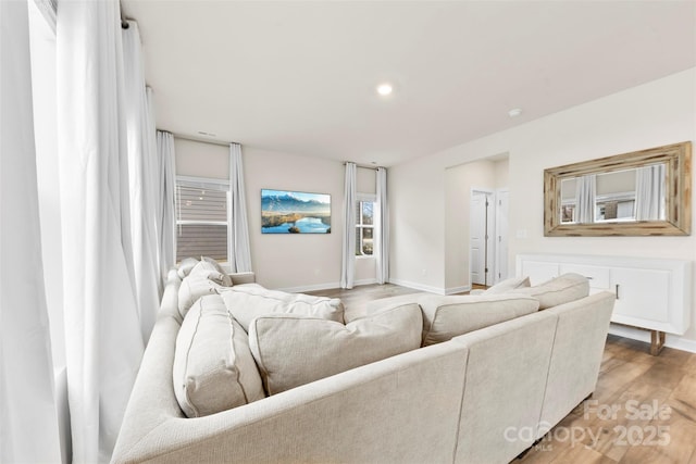 living room featuring recessed lighting, baseboards, and wood finished floors