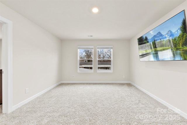 empty room with visible vents, baseboards, and carpet flooring