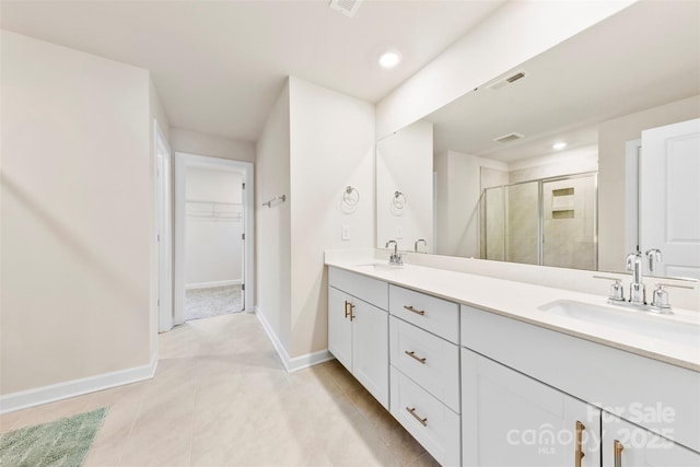 bathroom featuring a sink, visible vents, a stall shower, and a spacious closet