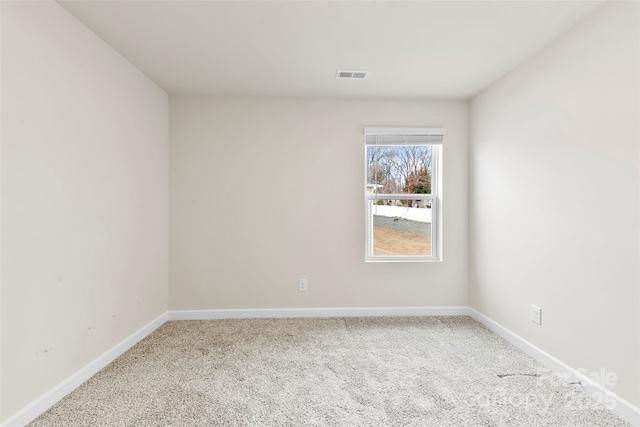 spare room with visible vents, carpet floors, and baseboards