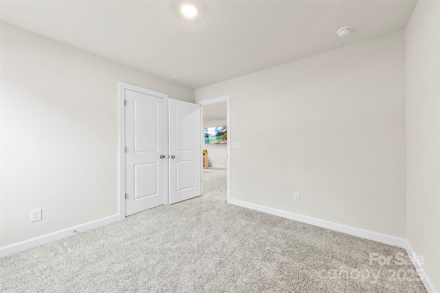 unfurnished bedroom with baseboards and carpet