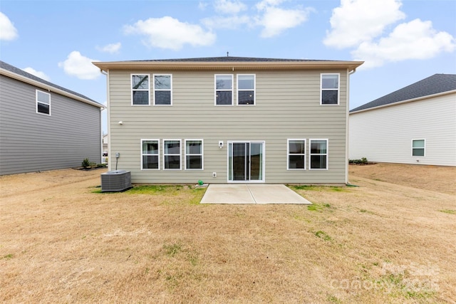 rear view of property featuring a yard, central air condition unit, and a patio area