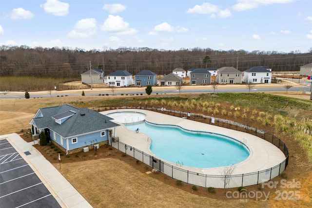 view of pool with a residential view and fence