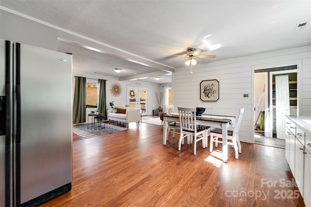 dining room featuring visible vents, light wood-style floors, and ceiling fan