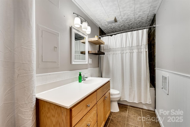 bathroom with vanity, toilet, shower / bath combo, and wainscoting