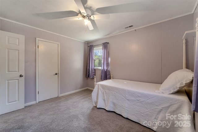 carpeted bedroom with visible vents, baseboards, a ceiling fan, and crown molding