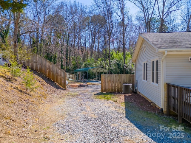 view of yard featuring central AC unit and fence