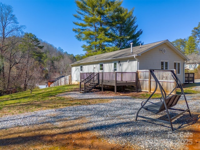 rear view of house with a wooden deck and stairs