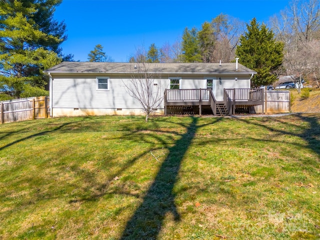 back of property with crawl space, a yard, a deck, and fence