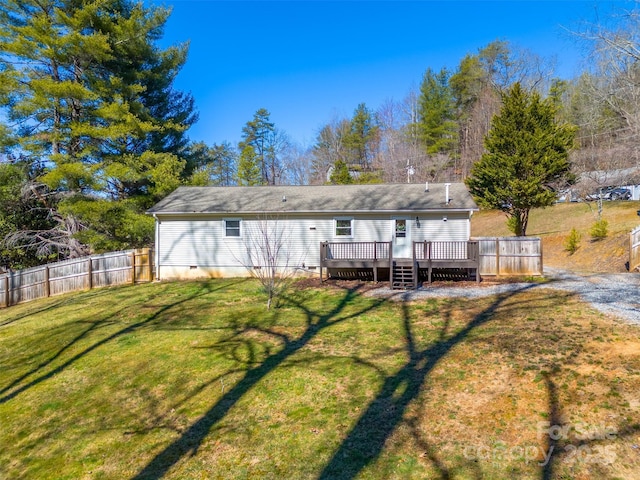 back of property featuring crawl space, a wooden deck, a lawn, and fence