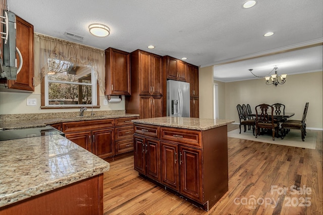 kitchen with visible vents, appliances with stainless steel finishes, ornamental molding, and light wood-style flooring