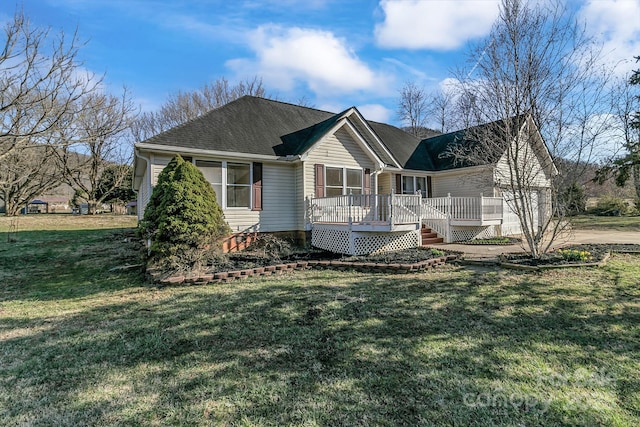 view of front of home with a front lawn, a shingled roof, and a deck
