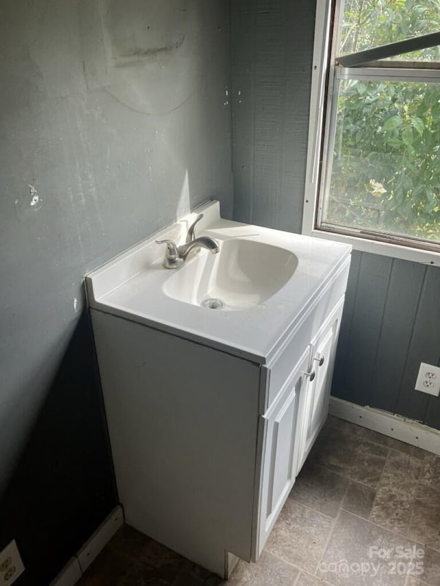 bathroom featuring stone finish flooring, plenty of natural light, and vanity