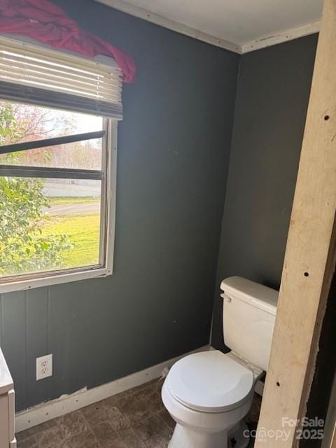 bathroom featuring toilet, vanity, and baseboards