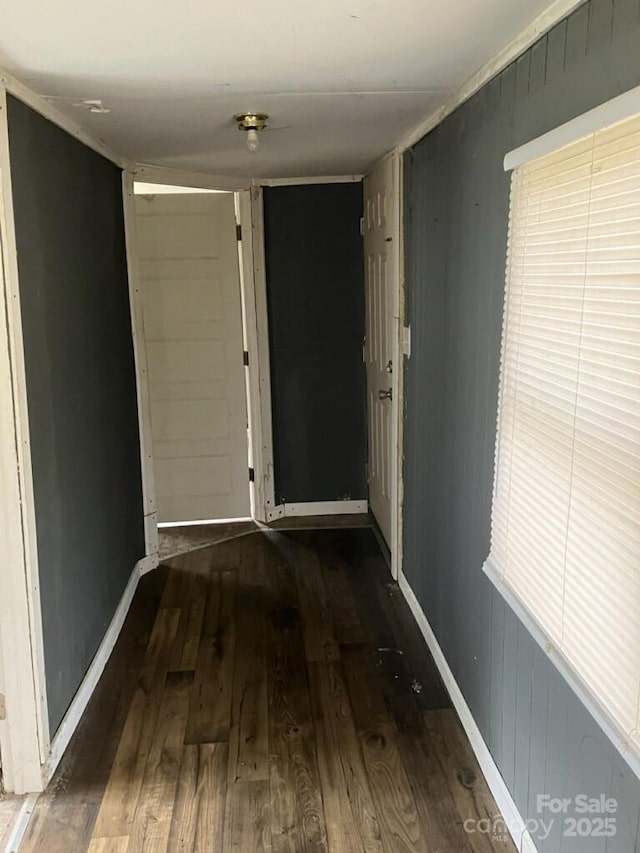 hall featuring baseboards and wood finished floors