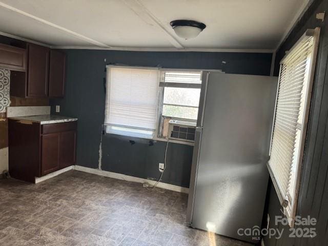 kitchen with freestanding refrigerator, cooling unit, dark brown cabinetry, light countertops, and baseboards