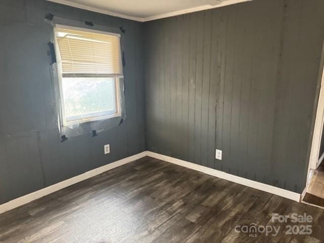 empty room with baseboards and dark wood finished floors