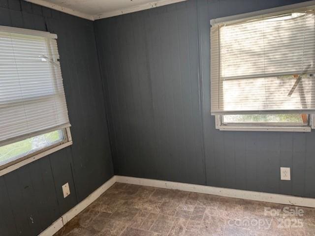 spare room with baseboards and wooden walls