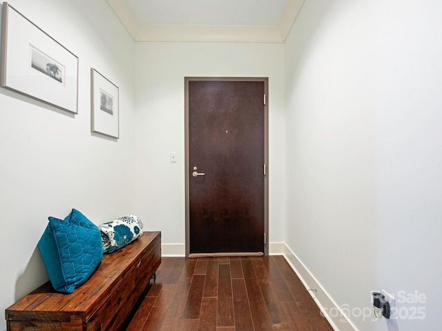 doorway to outside featuring baseboards and wood finished floors