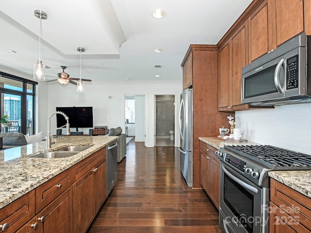 kitchen with dark wood-style floors, a sink, decorative backsplash, appliances with stainless steel finishes, and open floor plan