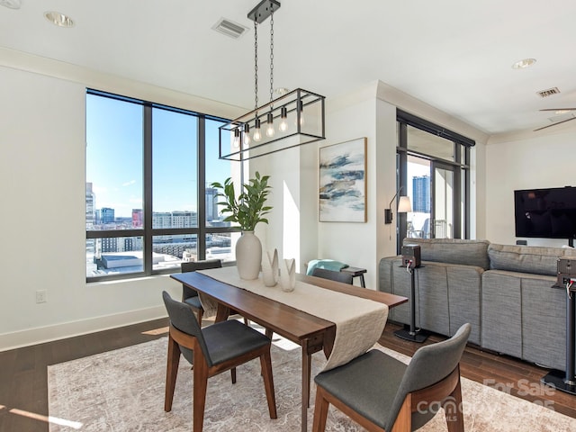 dining space with dark wood finished floors, a view of city, baseboards, and visible vents