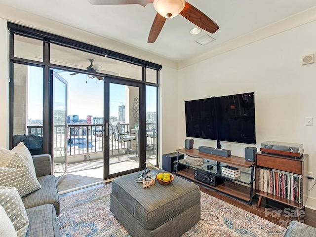 living area with a ceiling fan, wood finished floors, and baseboards