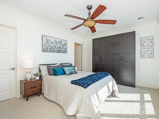 bedroom with a closet, ornamental molding, a ceiling fan, and carpet floors