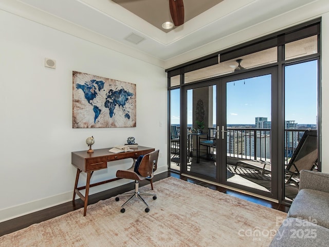 office featuring visible vents, a tray ceiling, wood finished floors, french doors, and baseboards