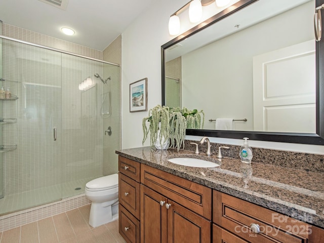 bathroom with tile patterned floors, a stall shower, toilet, and vanity