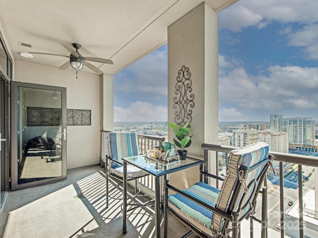 balcony featuring visible vents, a city view, and ceiling fan