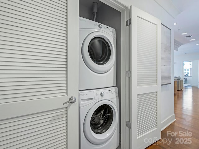 laundry area featuring wood finished floors, visible vents, laundry area, recessed lighting, and stacked washer / dryer