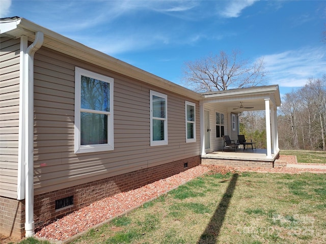 view of home's exterior featuring crawl space, a lawn, a patio, and ceiling fan