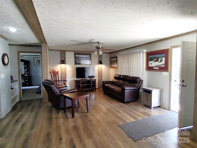 living area with ceiling fan, wood finished floors, and a textured ceiling