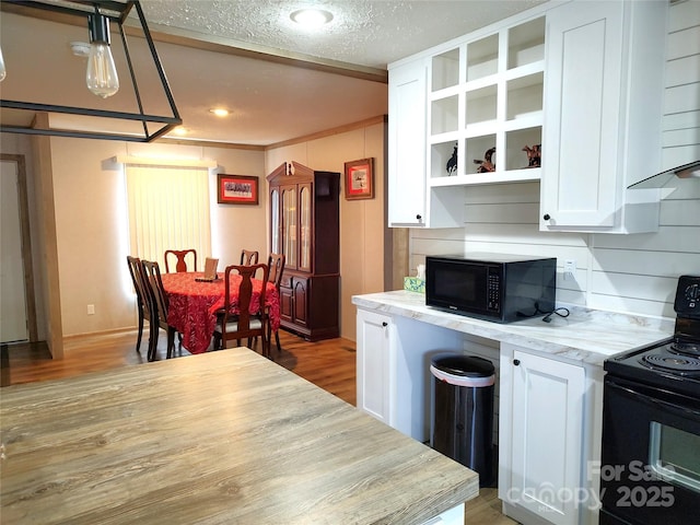 kitchen with black appliances, light wood-style floors, white cabinets, a textured ceiling, and open shelves