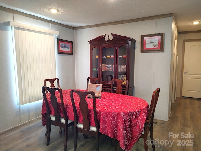 dining space with wood finished floors and a textured ceiling