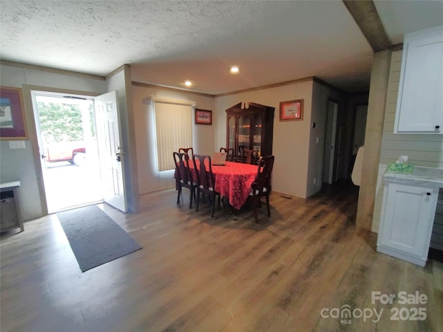 dining room with recessed lighting, a textured ceiling, and light wood-type flooring