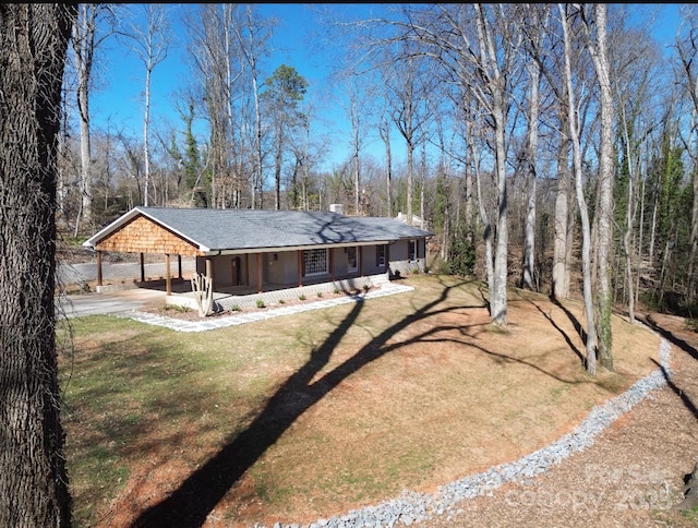 view of front of house featuring a carport, driveway, and a front yard