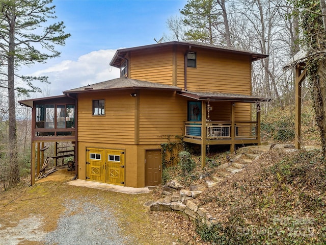 back of property with a sunroom and a wooden deck