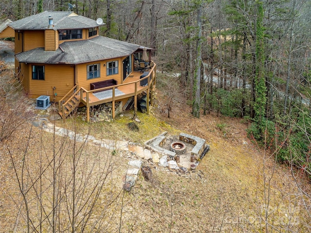 back of house with central air condition unit, a deck, an outdoor fire pit, stairway, and roof with shingles