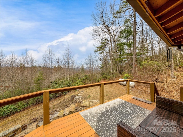 wooden terrace featuring a wooded view