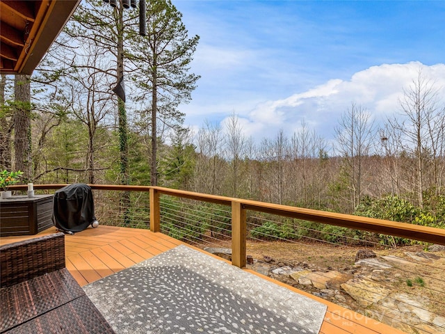 deck with a forest view and a grill