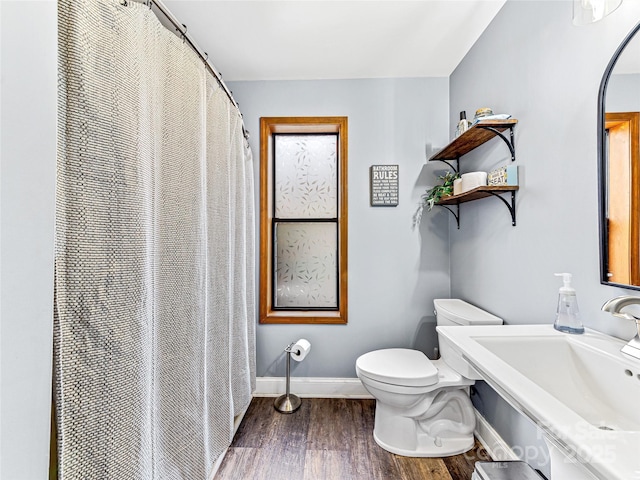 full bathroom featuring a shower with curtain, wood finished floors, baseboards, a sink, and toilet