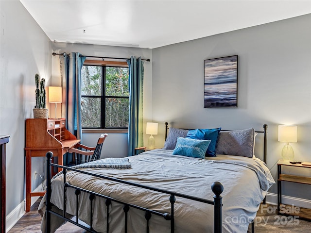 bedroom with wood finished floors and baseboards