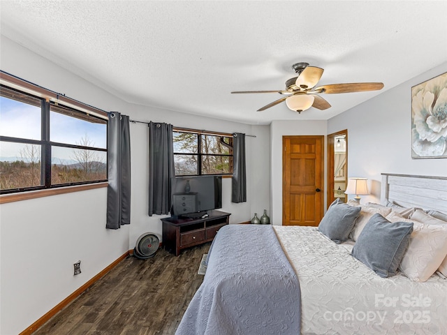 bedroom featuring dark wood-style floors, a textured ceiling, baseboards, and a ceiling fan