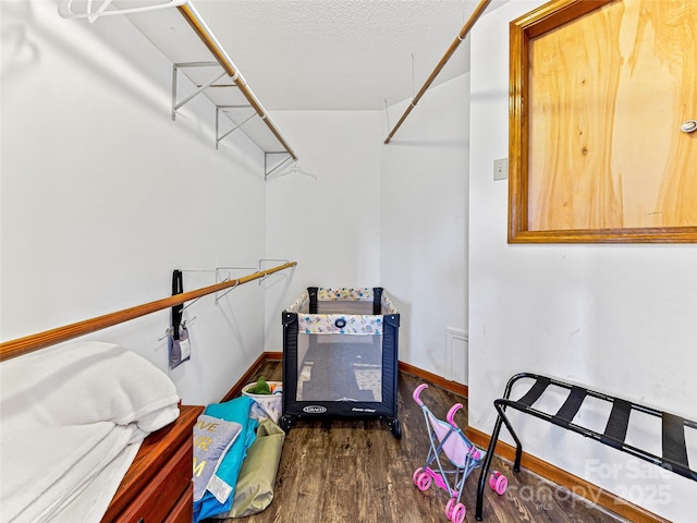 walk in closet with wood finished floors