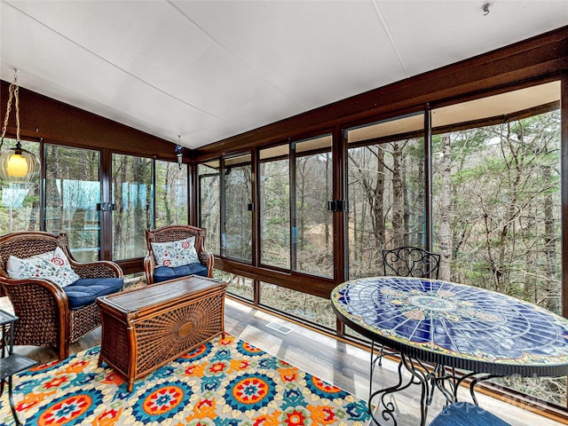 sunroom with plenty of natural light and vaulted ceiling